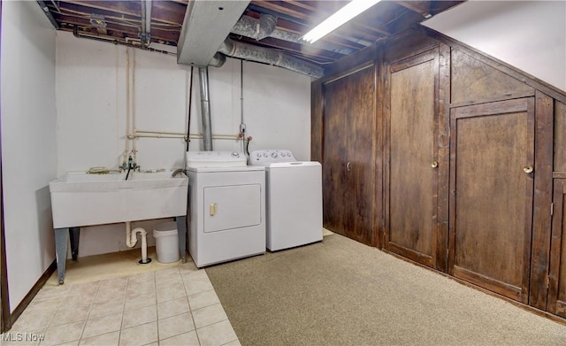 clothes washing area with washer and clothes dryer and light tile patterned floors