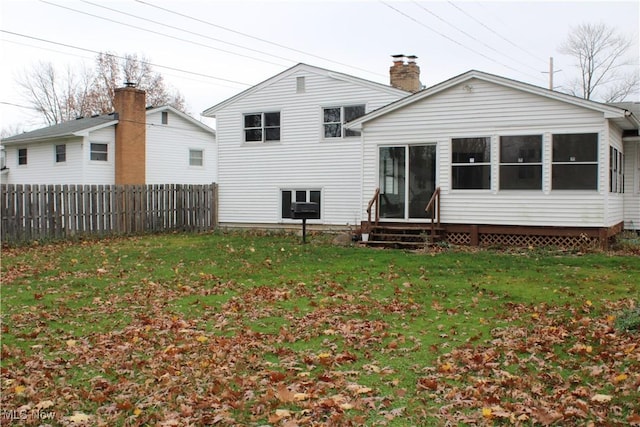 rear view of house featuring a yard