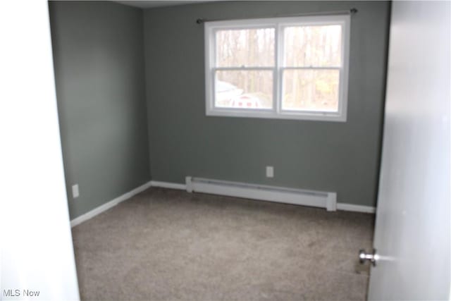 carpeted empty room with a baseboard radiator