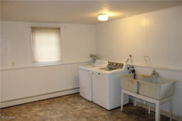 clothes washing area featuring washing machine and clothes dryer and a baseboard radiator