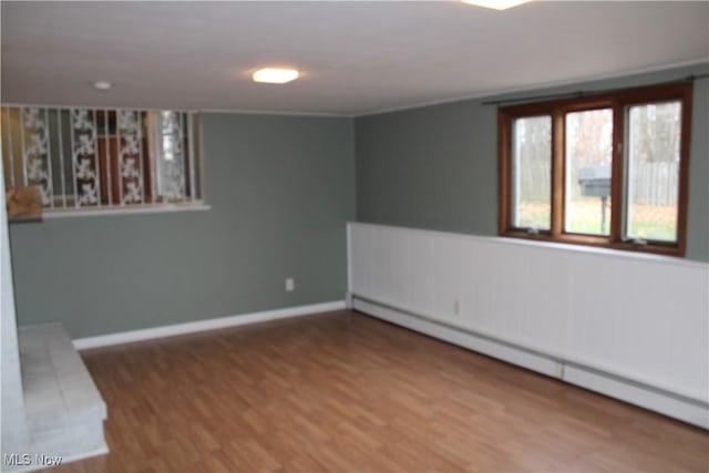 empty room featuring hardwood / wood-style flooring and baseboard heating