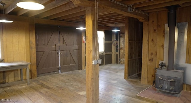 4101 Canfield Rd, Canfield, OH 44406 - below grade area with a wood stove, wood walls, and hardwood / wood-style flooring