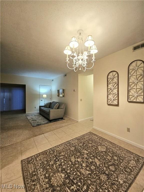 unfurnished living room with tile patterned floors and a notable chandelier