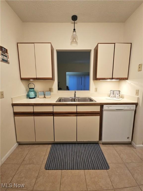 kitchen with dishwasher, light tile patterned floors, pendant lighting, and sink