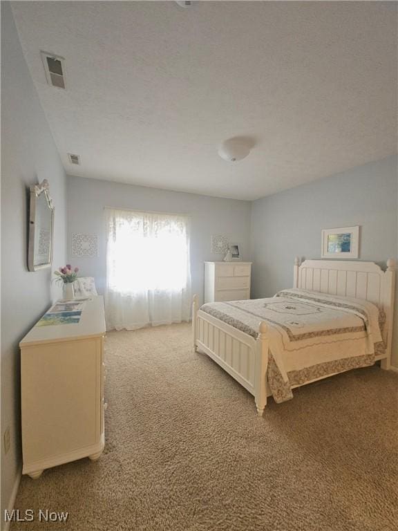 bedroom featuring light carpet and a textured ceiling