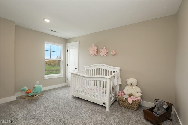 carpeted bedroom featuring a nursery area