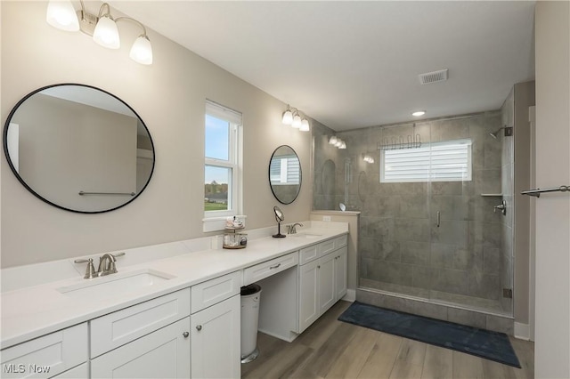 bathroom with vanity, wood-type flooring, and a shower with door