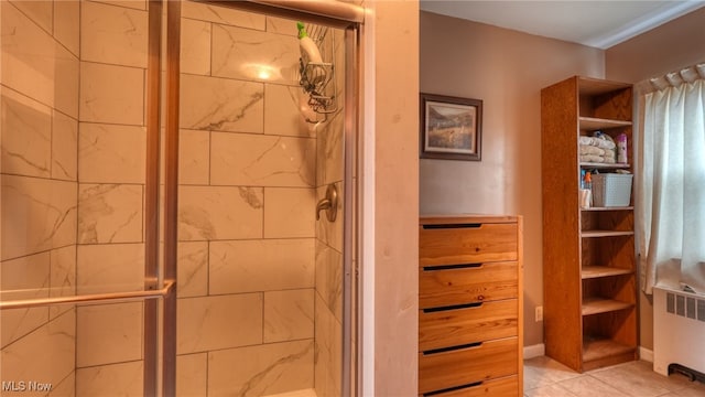 bathroom with radiator, tile patterned flooring, and a shower with shower door