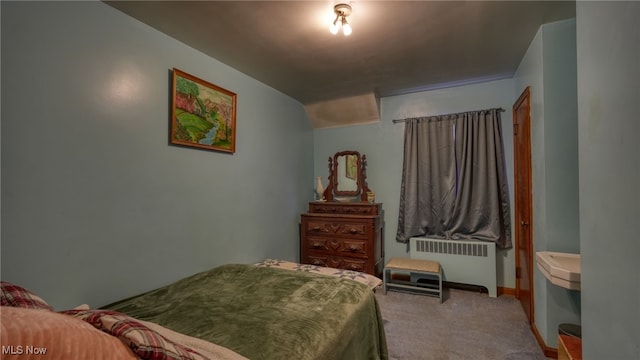 carpeted bedroom featuring radiator