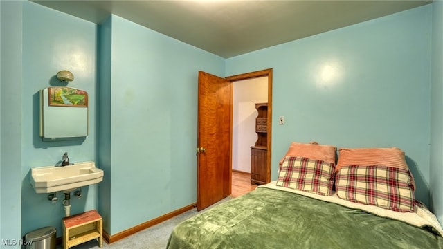 bedroom with light colored carpet and sink