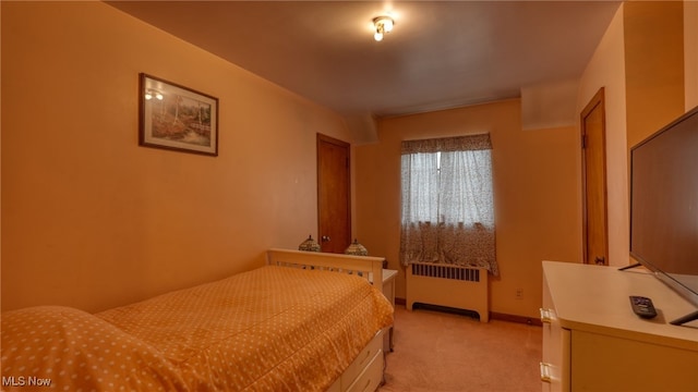 bedroom featuring light carpet and radiator