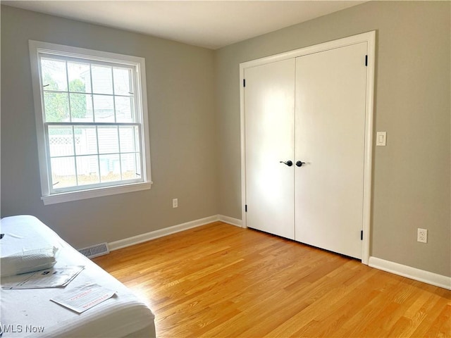 unfurnished bedroom with a closet and light hardwood / wood-style flooring