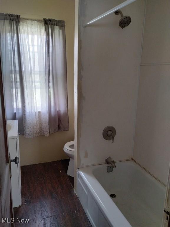 full bathroom featuring hardwood / wood-style floors, vanity, shower / bath combination, and toilet