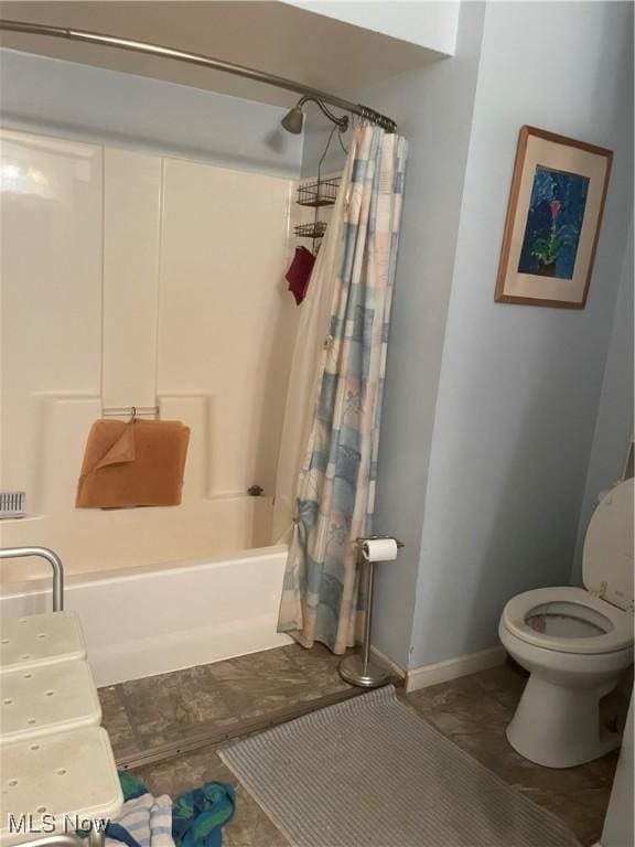 bathroom featuring tile patterned floors, shower / bath combination with curtain, and toilet