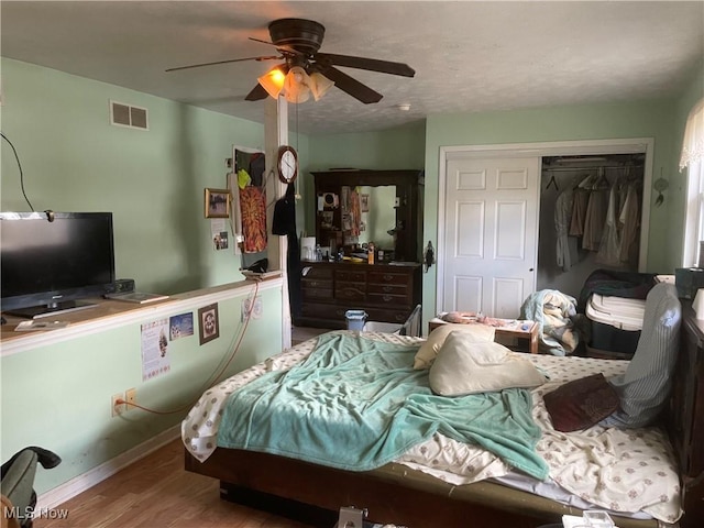 bedroom featuring hardwood / wood-style floors, a closet, and ceiling fan