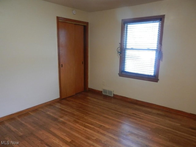 unfurnished room featuring dark hardwood / wood-style flooring