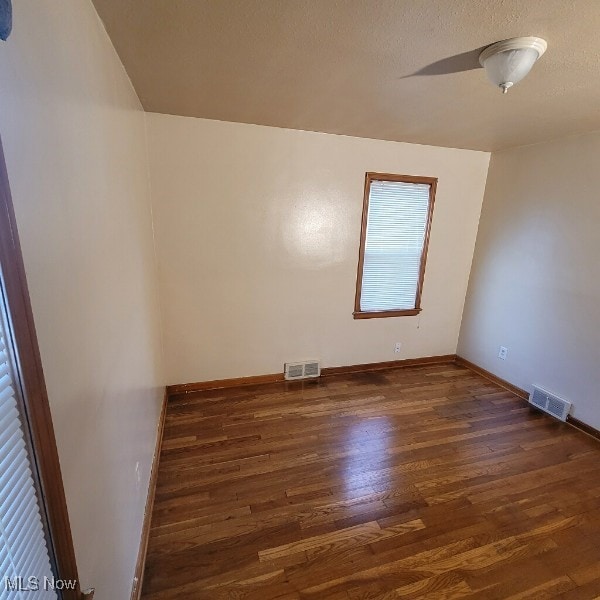 unfurnished room featuring ceiling fan and dark hardwood / wood-style flooring