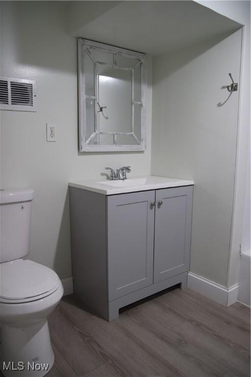 bathroom featuring toilet, vanity, and hardwood / wood-style flooring