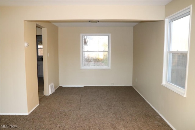 empty room with dark colored carpet