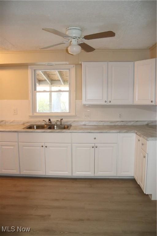 kitchen with ceiling fan, dark hardwood / wood-style flooring, white cabinets, and sink