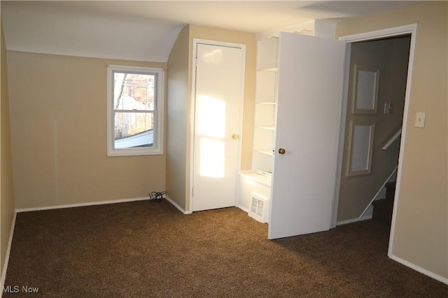 unfurnished bedroom with dark carpet