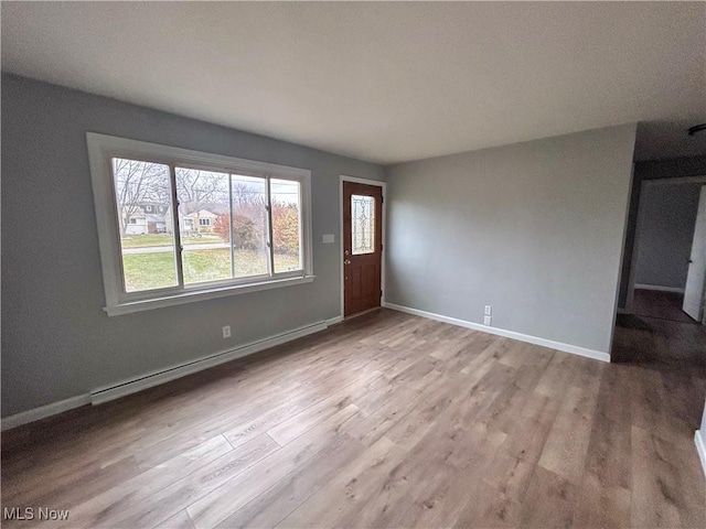 foyer entrance with baseboard heating and light hardwood / wood-style flooring