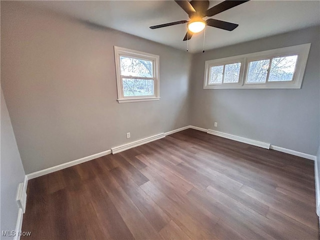 empty room with a baseboard radiator, dark hardwood / wood-style floors, and ceiling fan