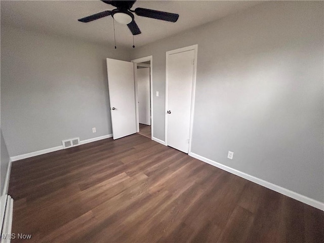 unfurnished bedroom featuring ceiling fan and dark hardwood / wood-style flooring