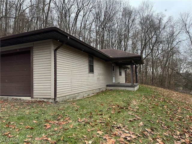 view of side of home with a garage and a lawn