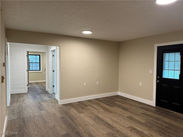 foyer entrance with a textured ceiling and dark hardwood / wood-style floors