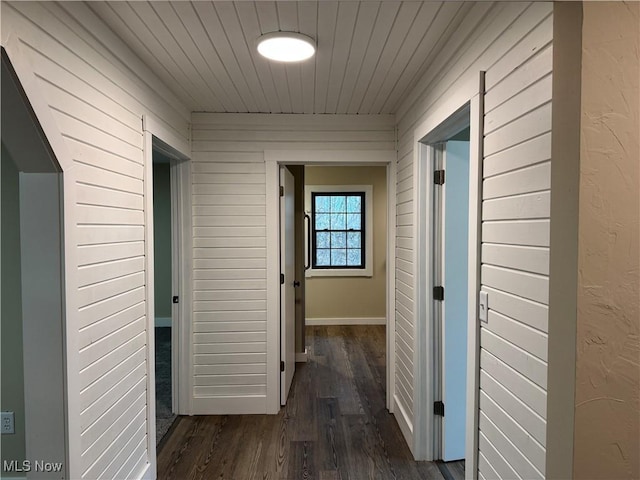 hall featuring wood walls and dark hardwood / wood-style flooring