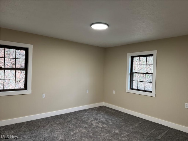 carpeted spare room featuring plenty of natural light