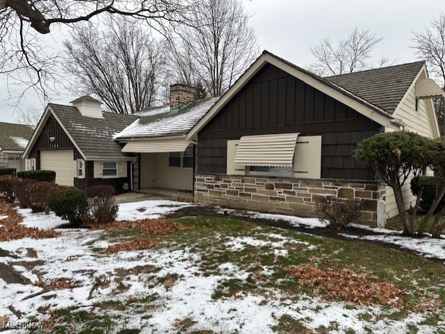 snow covered property with a garage