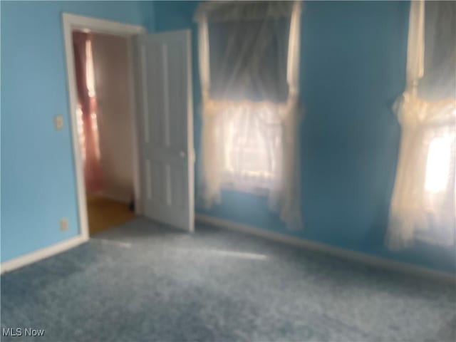 unfurnished room with plenty of natural light and carpet flooring