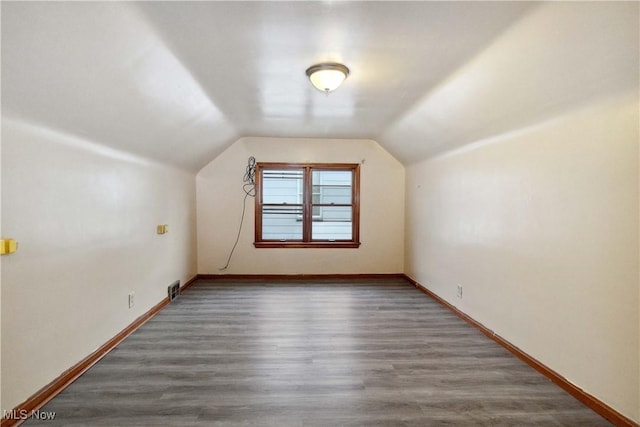 bonus room with lofted ceiling and dark hardwood / wood-style floors