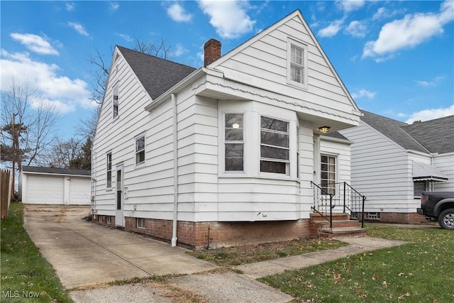 view of front of property featuring an outbuilding, a garage, and a front yard