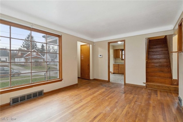 empty room featuring a wealth of natural light and hardwood / wood-style floors