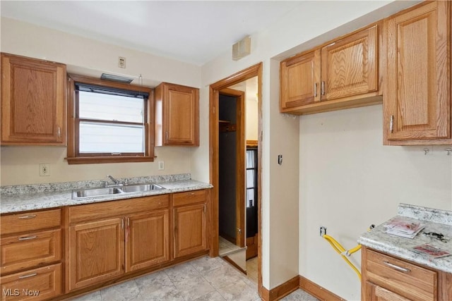 kitchen with light stone counters and sink