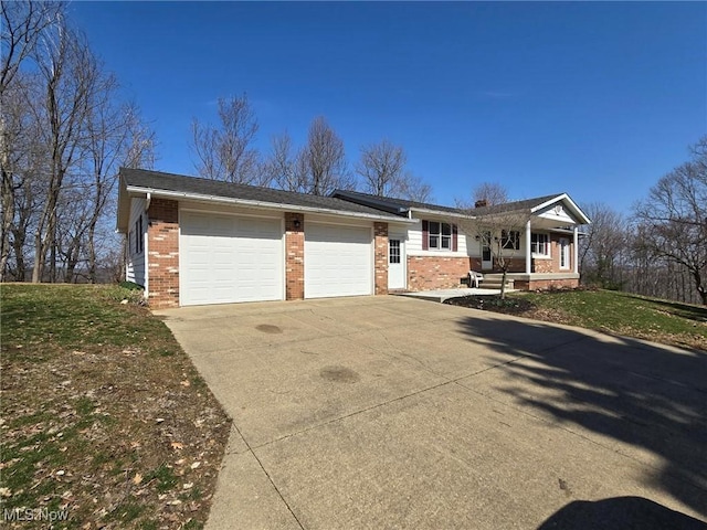 ranch-style home featuring a front lawn, brick siding, concrete driveway, and an attached garage