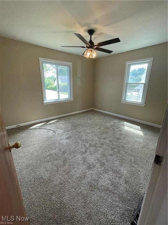 unfurnished room with carpet flooring and ceiling fan