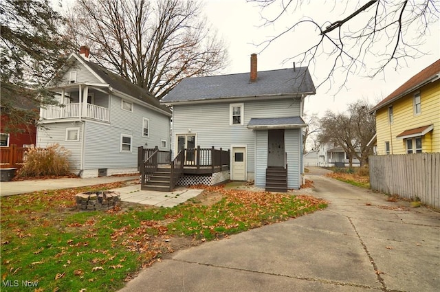 rear view of property with an outdoor fire pit and a wooden deck