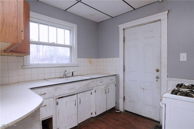 kitchen with backsplash, a paneled ceiling, sink, and dark wood-type flooring