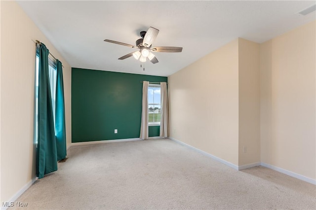 empty room featuring light colored carpet and ceiling fan