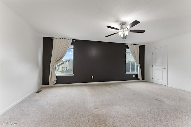 spare room with ceiling fan and light colored carpet