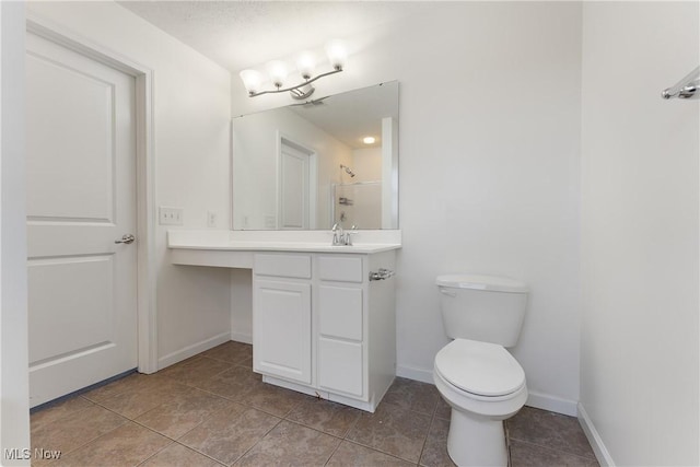 bathroom with tile patterned floors, vanity, toilet, and walk in shower