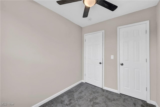 unfurnished bedroom with dark carpet and ceiling fan