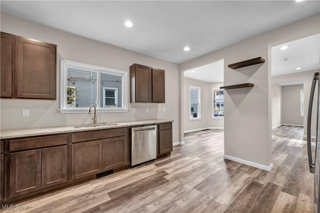 kitchen with dark brown cabinets, light hardwood / wood-style flooring, stainless steel dishwasher, and sink