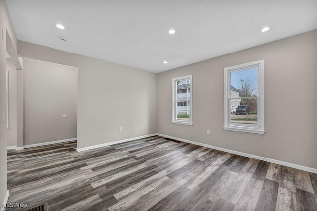 unfurnished room with dark wood-type flooring