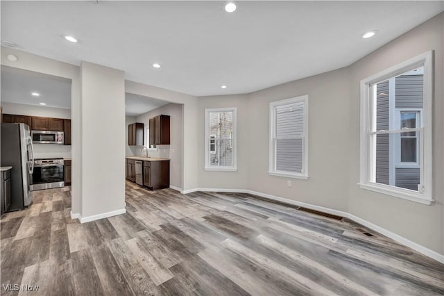 unfurnished living room with light hardwood / wood-style floors and sink