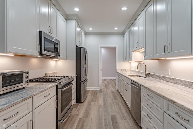 kitchen with white cabinetry, sink, stainless steel appliances, and light hardwood / wood-style floors